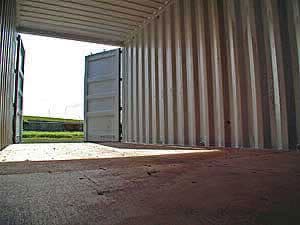 Looking out from inside an open, empty Containastore container across the yard