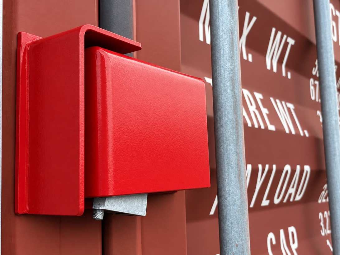 A welded steel lockbox fitted to a container door
